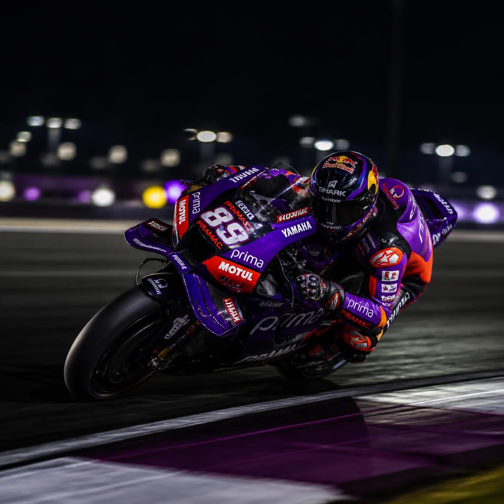 MotoGP bike leaning into a corner at a night race